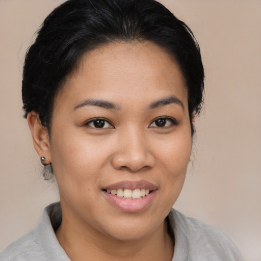Joyful latino young-adult female with short  black hair and brown eyes