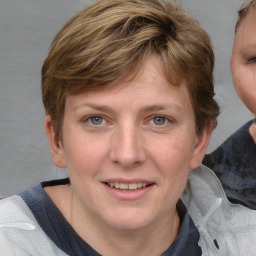 Joyful white young-adult female with medium  brown hair and blue eyes