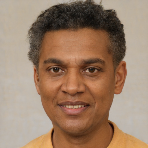 Joyful black adult male with short  brown hair and brown eyes