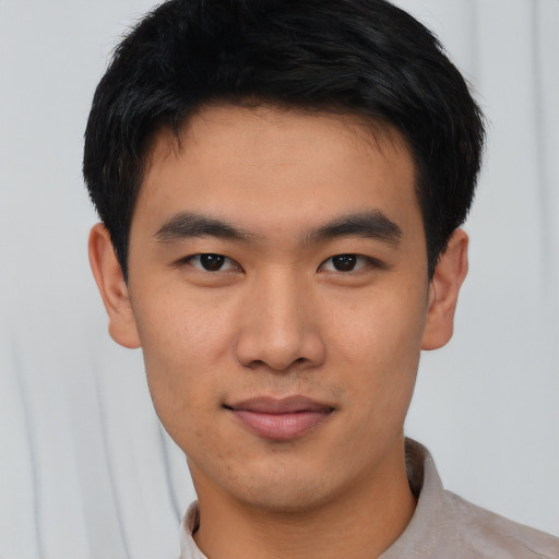 Joyful asian young-adult male with short  black hair and brown eyes