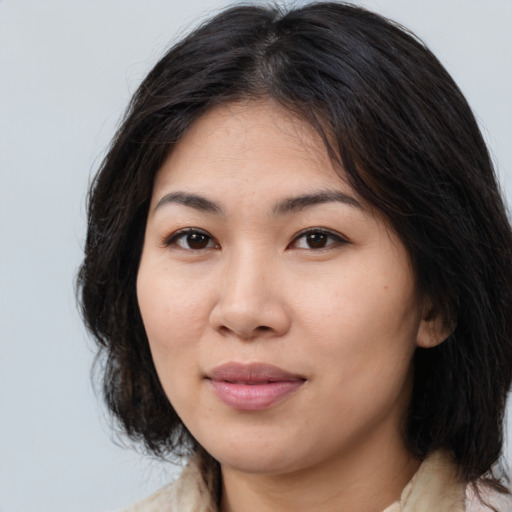Joyful asian young-adult female with medium  brown hair and brown eyes
