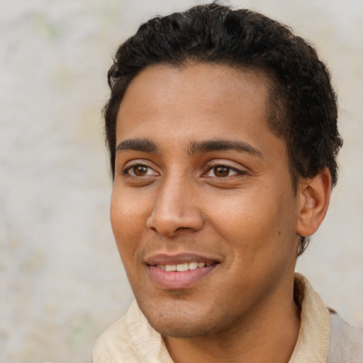 Joyful latino young-adult male with short  brown hair and brown eyes