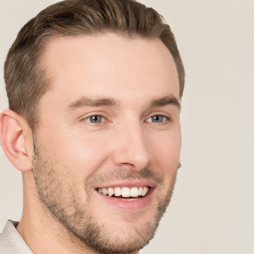 Joyful white young-adult male with short  brown hair and grey eyes