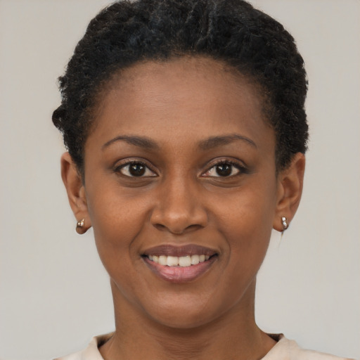 Joyful black young-adult female with short  black hair and brown eyes