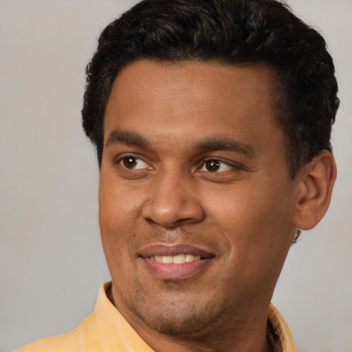 Joyful latino young-adult male with short  black hair and brown eyes