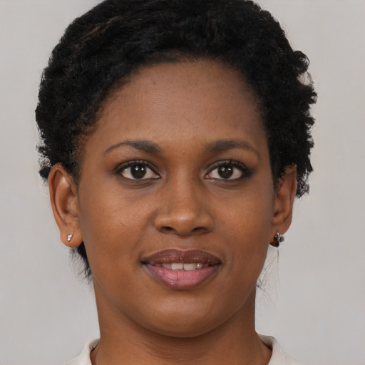 Joyful black young-adult female with short  brown hair and brown eyes