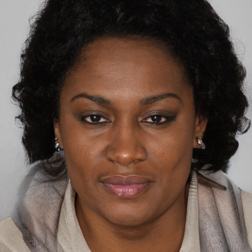 Joyful black adult female with medium  brown hair and brown eyes