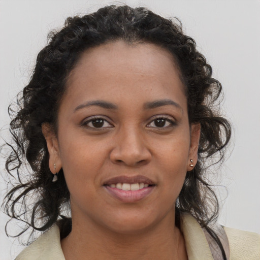 Joyful black young-adult female with long  brown hair and brown eyes