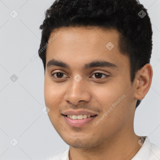 Joyful latino young-adult male with short  black hair and brown eyes