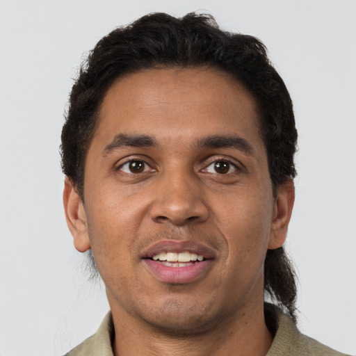 Joyful black young-adult male with short  brown hair and brown eyes