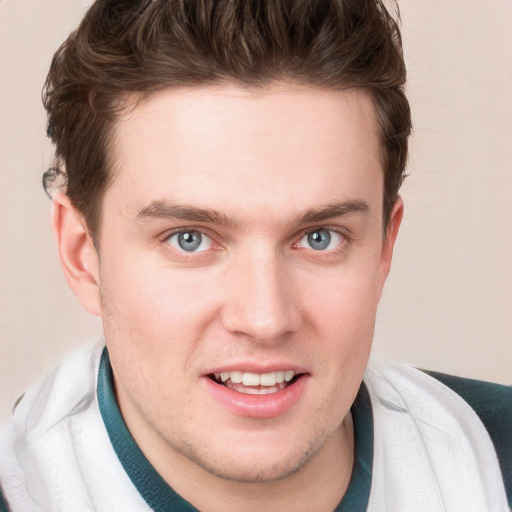 Joyful white young-adult male with short  brown hair and blue eyes