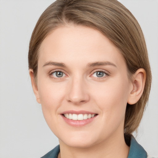 Joyful white young-adult female with medium  brown hair and grey eyes