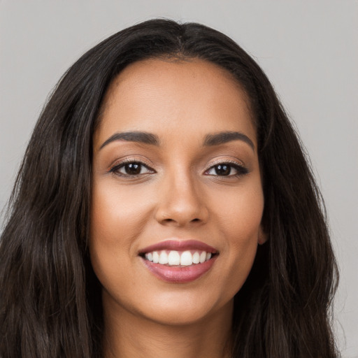 Joyful latino young-adult female with long  brown hair and brown eyes