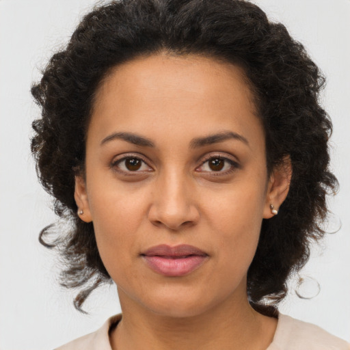 Joyful latino adult female with medium  brown hair and brown eyes