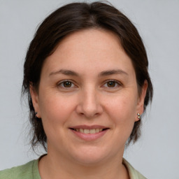 Joyful white adult female with medium  brown hair and grey eyes