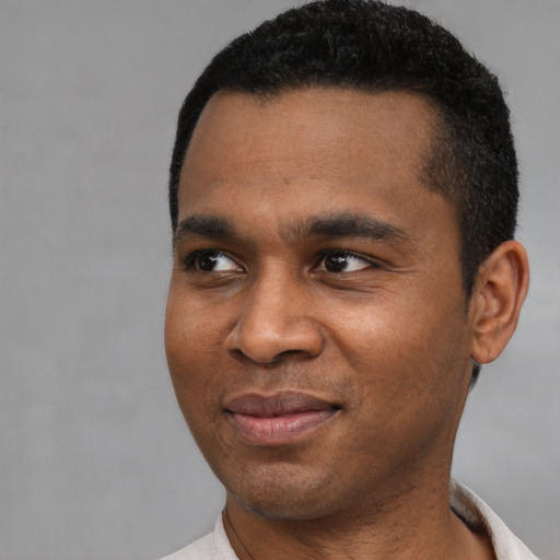 Joyful latino young-adult male with short  black hair and brown eyes