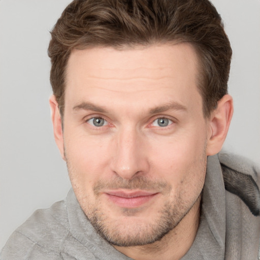 Joyful white adult male with short  brown hair and grey eyes