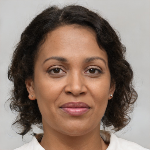 Joyful black adult female with medium  brown hair and brown eyes