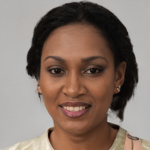 Joyful black young-adult female with short  black hair and brown eyes