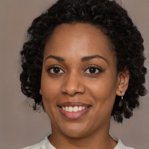 Joyful black young-adult female with medium  black hair and brown eyes