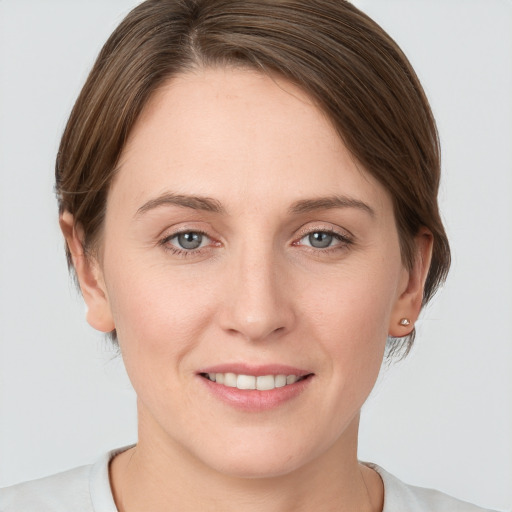 Joyful white young-adult female with medium  brown hair and grey eyes