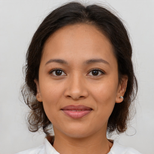 Joyful latino young-adult female with medium  brown hair and brown eyes