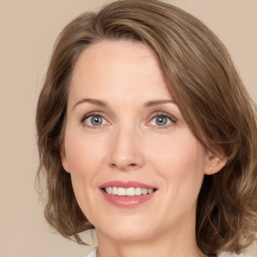 Joyful white young-adult female with medium  brown hair and green eyes