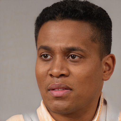 Joyful black young-adult male with short  brown hair and brown eyes