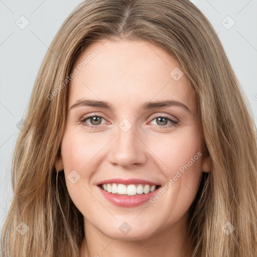 Joyful white young-adult female with long  brown hair and green eyes