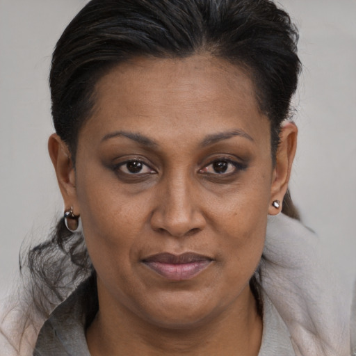 Joyful black adult female with medium  brown hair and brown eyes