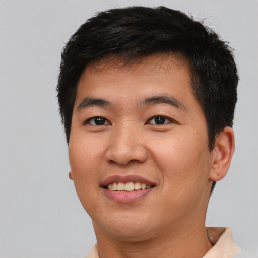 Joyful asian adult male with short  brown hair and brown eyes
