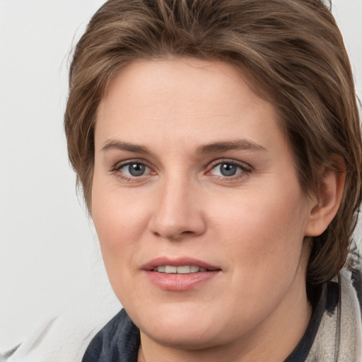 Joyful white young-adult female with medium  brown hair and grey eyes