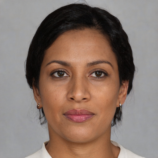 Joyful latino adult female with medium  black hair and brown eyes