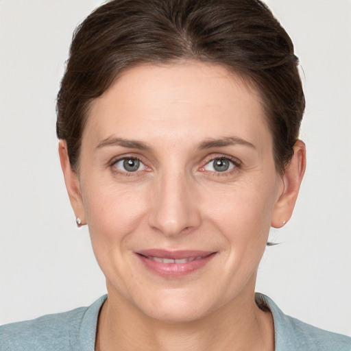 Joyful white young-adult female with short  brown hair and grey eyes