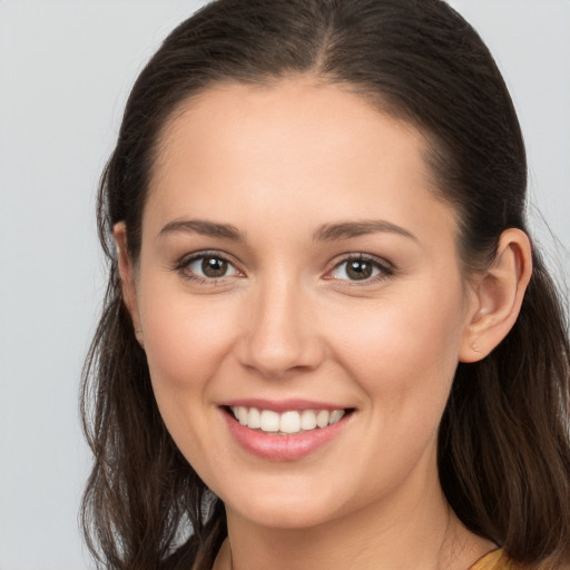 Joyful white young-adult female with long  brown hair and brown eyes