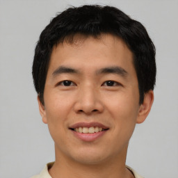 Joyful asian young-adult male with short  black hair and brown eyes