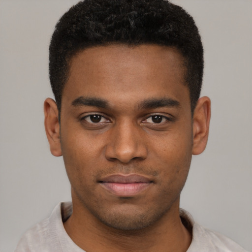 Joyful black young-adult male with short  brown hair and brown eyes