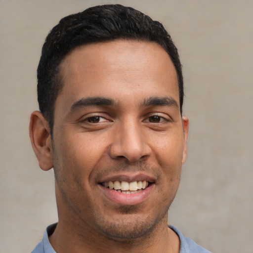 Joyful latino young-adult male with short  brown hair and brown eyes