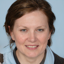 Joyful white adult female with medium  brown hair and blue eyes