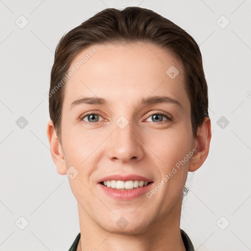 Joyful white young-adult male with short  brown hair and grey eyes