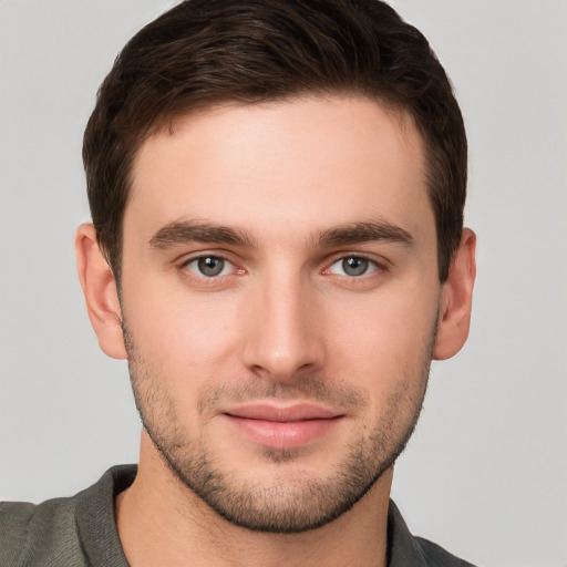 Joyful white young-adult male with short  brown hair and grey eyes