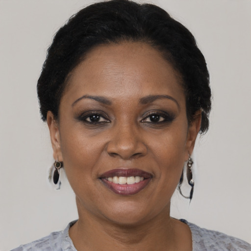 Joyful black adult female with short  black hair and brown eyes