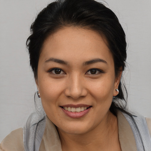 Joyful latino young-adult female with medium  brown hair and brown eyes