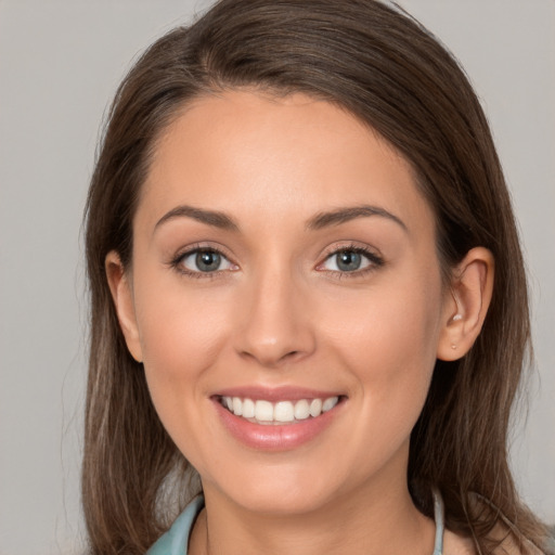 Joyful white young-adult female with long  brown hair and grey eyes