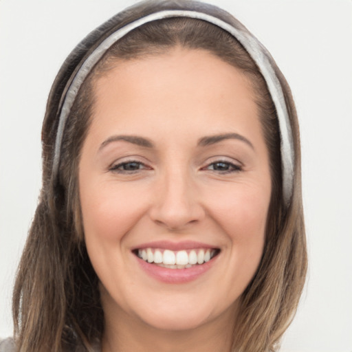 Joyful white young-adult female with long  brown hair and brown eyes