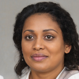 Joyful black young-adult female with long  brown hair and brown eyes