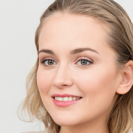 Joyful white young-adult female with long  brown hair and blue eyes