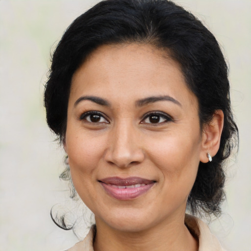 Joyful latino adult female with medium  brown hair and brown eyes