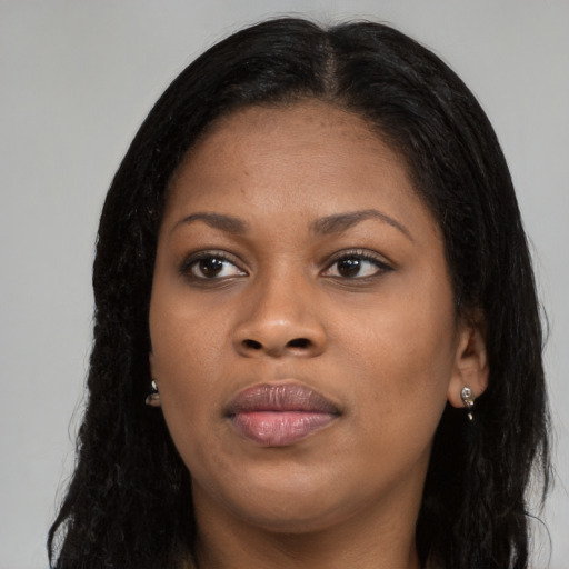 Joyful black young-adult female with long  brown hair and brown eyes