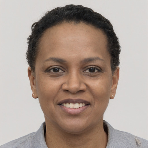 Joyful black young-adult female with short  brown hair and brown eyes